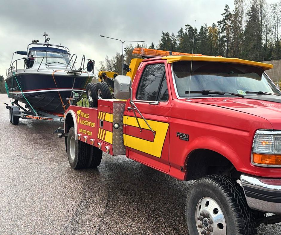 veneen kuljetus punaisella hinausautolla